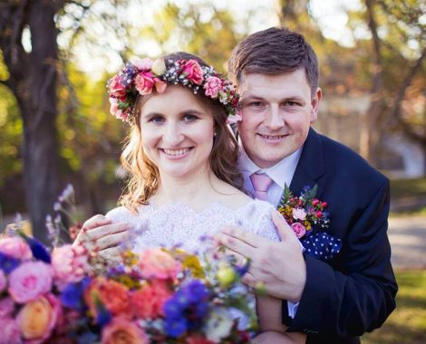 nevěsta se svatebním věnečkem a svatební kyticí v lučním stylu se ženichem s koršáží